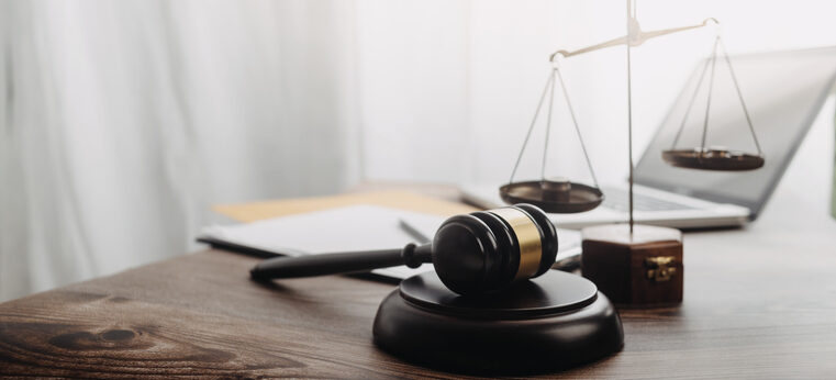 Business and lawyers discussing contract papers with brass scale on desk in office. Law, legal services, advice, justice and law concept picture with film grain effect